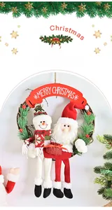 Détail d'une couronne de Noël avec peluches Père Noël et bonhomme de neige sur un cercle de rotin