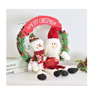 Détail d'une couronne de Noël avec aiguilles de pin, cônes, figurines Père Noël et Bonhomme