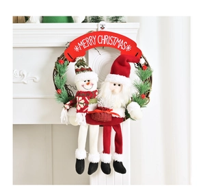 Détail des peluches Père Noël et Bonhomme de neige sur une couronne de Noël au foyer