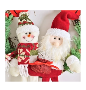 Détail de couronne de Noël avec figurines en peluche Père Noël et Bonhomme de neige