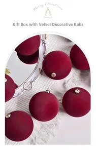 Close-up of red flocked Christmas balls with gold caps on white knit fabric background