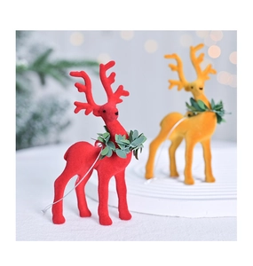 Close-up of flocked Christmas reindeer ornaments with leaf wreaths and silver hanging loops