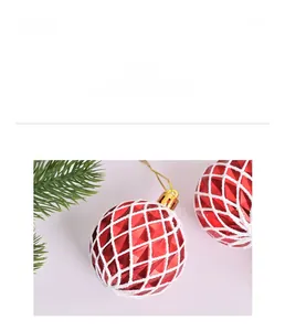 Détail de boule de Noël rouge avec texture quadrillée blanche, calotte dorée et cordon