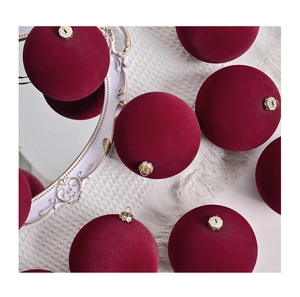 Detail of burgundy flocked velvet Christmas balls on a vintage tray with elegant texture