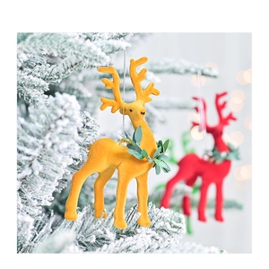 Close-up of flocked Christmas reindeer ornaments with leaf wreaths on a festive tree