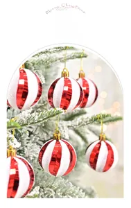 Close-up of red and white striped Christmas ball with glitter on a snowy tree branch