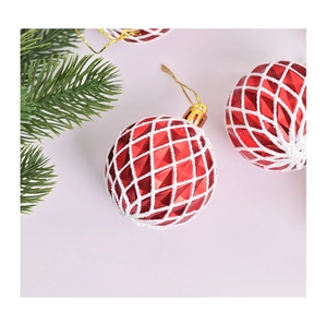 Gros plan sur une boule de Noël rouge de 6 cm avec motif losange blanc et cordon doré