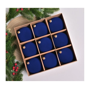 Detailed close-up of nine 10cm dark blue flocked velvet Christmas balls in a gift box