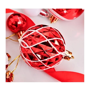 Detalle macro de bola de Navidad roja geométrica con patrones de purpurina blanca y tapa dorada
