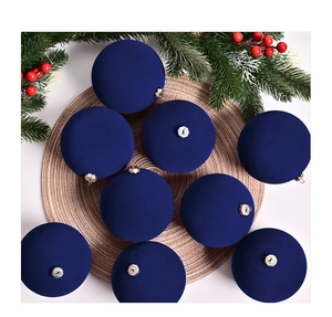 Close-up of 9-piece set of deep blue flocked Christmas balls with silver caps on a woven mat