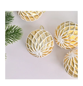 Détail de boules de Noël dorées avec texture diamant 3D et motifs de grille givrée blanche