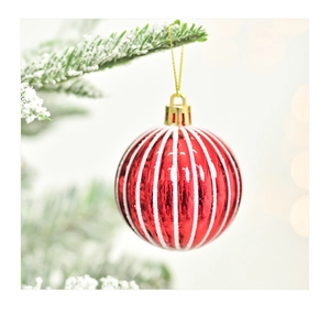 Close-up van rood-witte gestreepte kerstbal met glitters aan een dennentak op boom