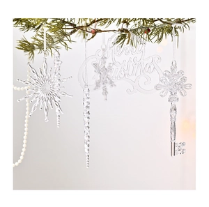 Gros plan d'ornements transparents en forme de glaçons et flocons sur un sapin de Noël