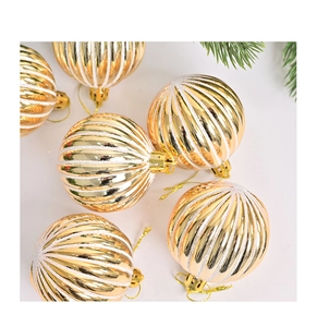 Detail van gouden kerstballen met witte glitterstrepen en decoratieve dennennaalden