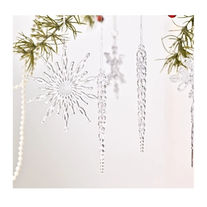 Détail de flocons de neige et glaçons en acrylique transparent sur une branche de sapin