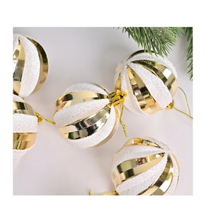 Macro detail of white glitter and gold striped Christmas baubles with golden hooks