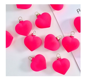 Detail showing neon pink flocked heart ornaments with silver metal caps and hanging loops
