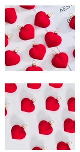 Detail of red flocked heart ornaments with gold loops for festive tree decoration