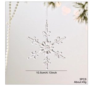 Trois ornements de flocons de neige transparents avec rubans blancs sur un sapin