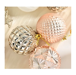 Close-up of assorted Christmas balls with textured plating on white faux fur background