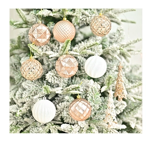 Detail of luxury champagne gold Christmas ornaments on snowy pine tree branches