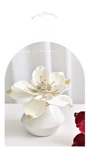 Detail of white velvet magnolia with gold glitter and crystals in a ceramic vase