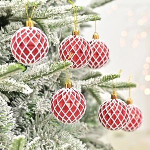 Boules de Noël rouges 6cm avec motifs de losanges blancs sur un sapin enneigé