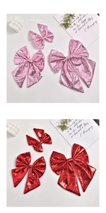 Close-up of pink and red sequin Christmas bows in three sizes with festive decor