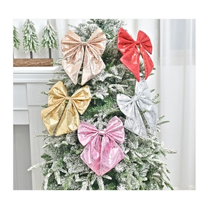 Detailed view of colorful sequined Christmas bows on a snow-covered holiday tree