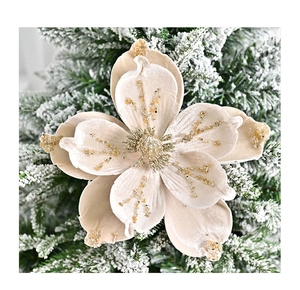 Macro detail of champagne velvet Christmas flower with gold glitter on snowy tree