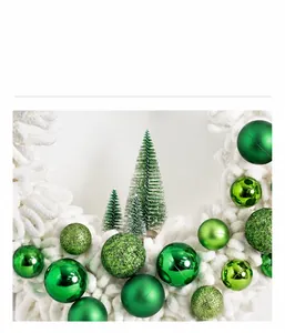 Detail of plush Christmas wreath with green ornaments and mini tree on white fabric