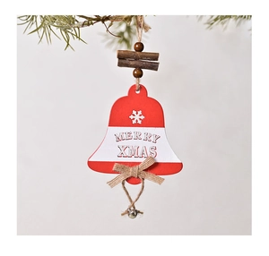 Detail of red wooden bell ornament with Merry Xmas text and bow on a pine branch