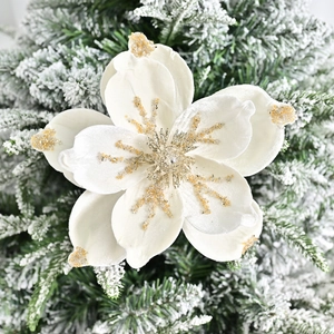 White velvet magnolia Christmas flower with gold glitter edges on snow branch