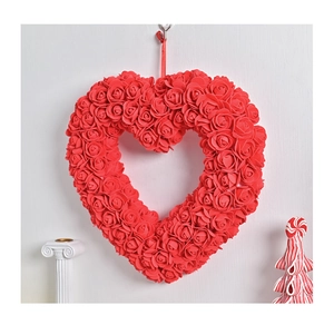 Détail d'une couronne en cœur de roses rouges avec ruban pour décoration de mariage
