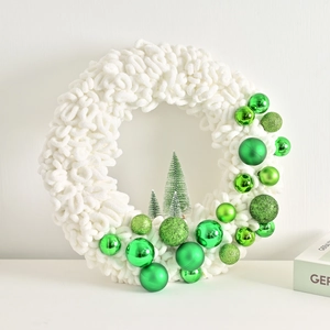 White chunky yarn Christmas wreath with green ornaments and miniature snowy pine trees