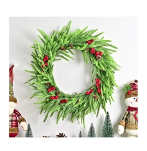 Detailansicht eines künstlichen Weihnachtskranzes mit roten Beeren und Tannenzapfen