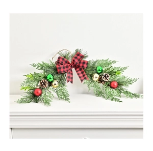 Detail of Christmas swag with red plaid bow, artificial pine needles, and pine cones