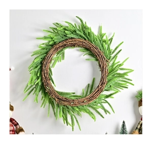 Detail eines Weihnachtskranzes mit künstlichen Tannennadeln auf einer Basis aus Rattan
