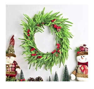 Detailansicht eines Weihnachtskranzes mit grünen Nadeln, roten Beeren und echten Zapfen