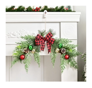 Detail of Christmas wreath with buffalo plaid bow, pine cones, and festive ornaments