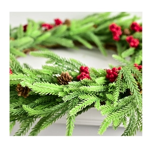 Nahaufnahme von künstlichen Kiefernnadeln, roten Beeren und Tannenzapfen am Weihnachtskranz