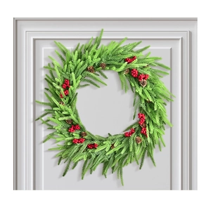 Detail eines künstlichen Weihnachtskranzes mit Kiefernnadeln, roten Beeren und Zapfen