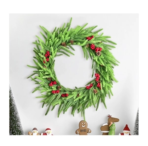 Detailansicht eines Weihnachtskranzes mit roten Beeren, Tannennadeln und Zapfen