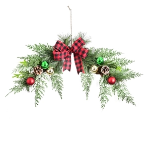 Christmas pine swag with red buffalo plaid bow and colorful ornaments on white background