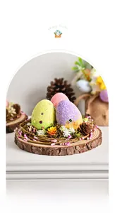 Gros plan d'oeufs de Pâques dans un nid en rotin sur socle en bois avec mousse et pommes de pin