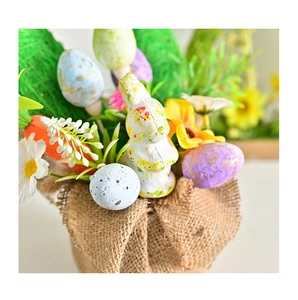 Close-up of Easter decoration with rabbit figurine, colorful eggs and burlap base
