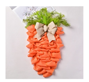 Détail d'une couronne de carotte en toile de jute orange avec feuilles vertes et nœud rustique