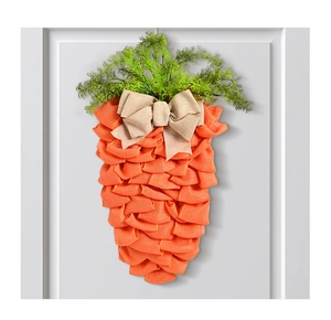 Gros plan d'une couronne de carotte en maille pour Pâques avec nœud en toile