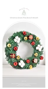 Detail of Christmas wreath with green pine branches, red balls and cotton flowers