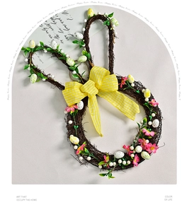Detail of Easter bunny wreath with rattan base, spring flowers, eggs and a plaid bow